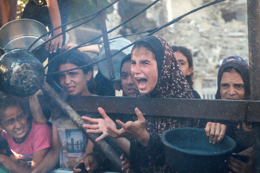 A Palestinian girl cries out for food with her hands held out at a charity kitchen amid the famine in Gaza. She is surrounded by other young, anguished children. This photo was taken on Thurs July 11, 2025 after at least 10 children were killed by an Israeli strike as they queued outside a medical point. More Palestinians have now been killed just waiting for food than the number of victims killed in the Hamas terrorist attack of October 7.
Photograph credit is to Ebrahim Hajjaj of Reuters