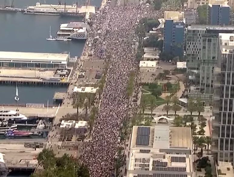 Overhead shot showing thousands filling the streets by the water’s edge, stretching as far as you can see. Photo credit to Scott Dworking