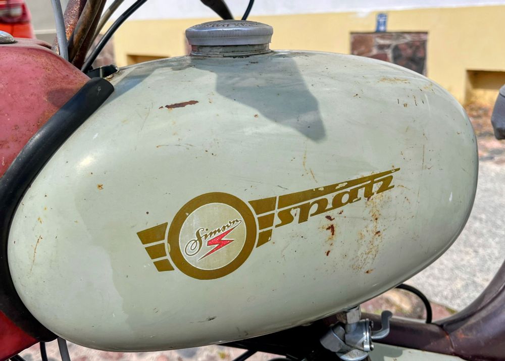 Metalltank. Er ist lindgrün, und in brauner Schrift steht darauf: Simson Spatz.