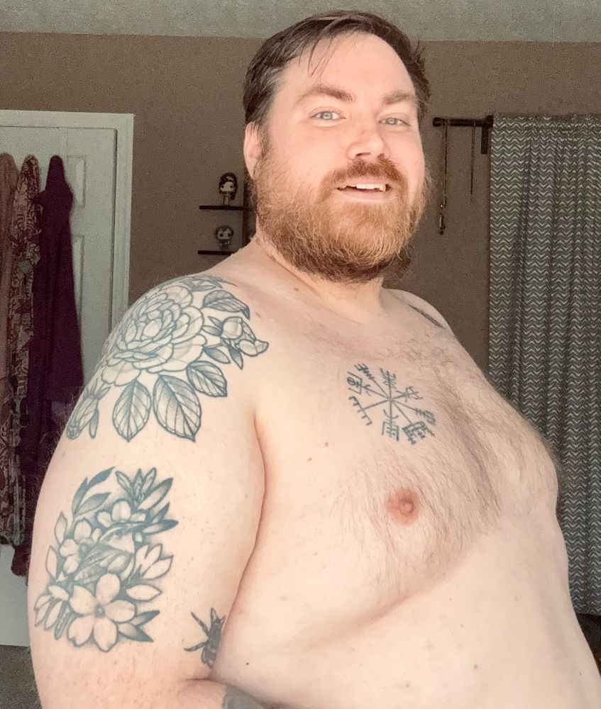 Selfie in my bedroom, shirtless post shower. From belly up. I’m smiling at the camera. 