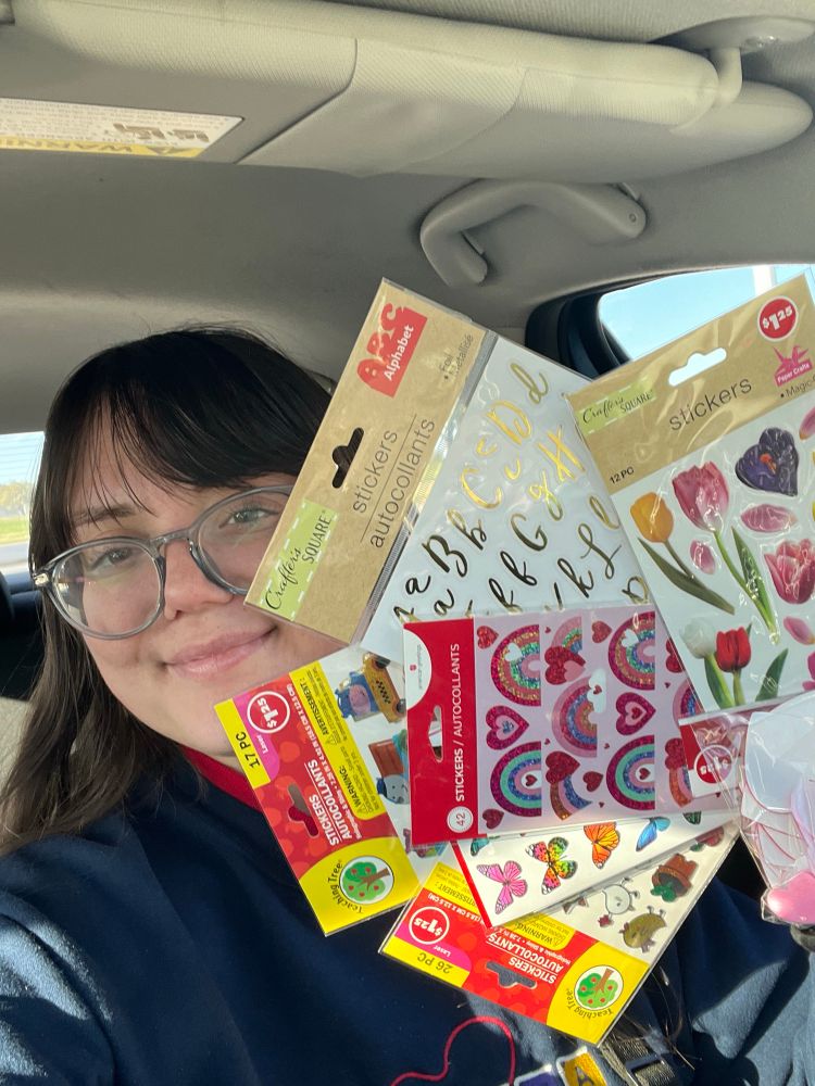 Clare holding various cute sticker packs