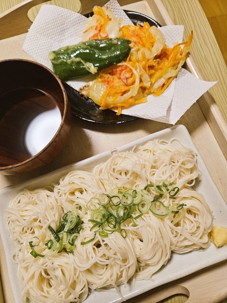 下の四角い皿にそうめん。刻みネギとチューブしょうがを添えています。右上の黒い皿に玉ねぎにんじん小エビのかき揚げと、ピーマンの天ぷらを盛り付けています。
青空ごはん部