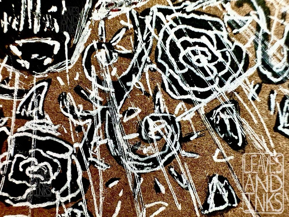 Crop focusing on the roses and vines.  details such as the thorns and leaves are more apparent. The wolf’s nose is also visible in the top left corner. The left most rose is slightly cropped, along with the ends of the sketchy, radial lines.  