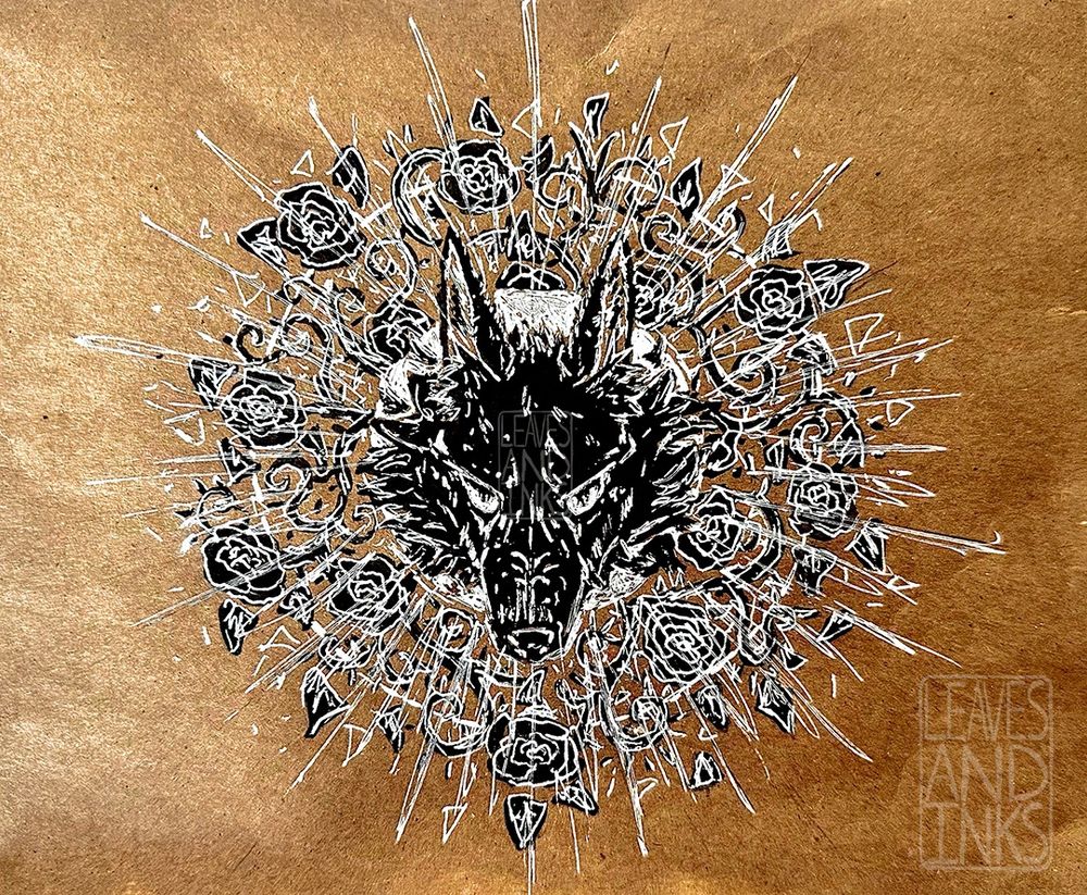 black and white ink illustration of a  wolf head on toned tan paper. It glares angrily at the viewer, looking up through its brow and its nose pointed down. Its drawn in black with white details, and Its ears are pointed up and back, and it has wild long fur on its cheeks. it overlaps a white circle behind it. In a larger circle surrounding the wolf head are vines with roses, leaves, and thorns. The roses are black, and the petals are drawn in white. Most of the thorns, vines, and leaves are colored in black, but some are just a white outline. the roses break out from a larger circle behind them and the wolf drawing, this one just bring a white outline. Over top of the roses, radiating out from the center of the wolf’s head, are sketchy white lines.  the paper is thin, and has a slight scaled pattern to it.