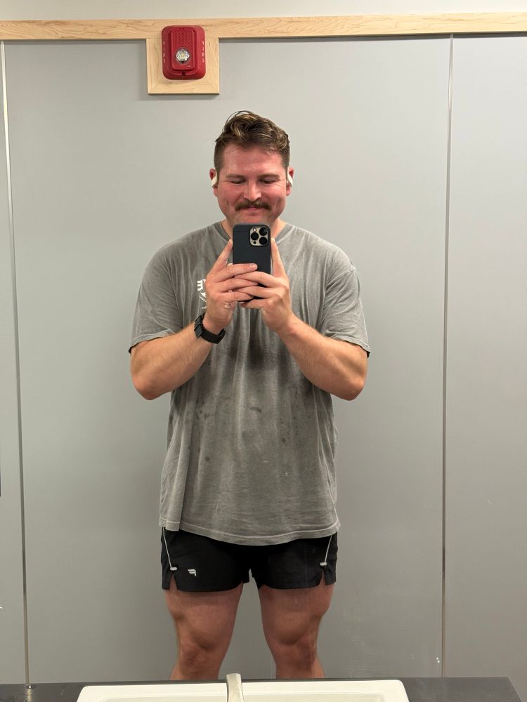 Dude, posing in gym mirror, flexing quads