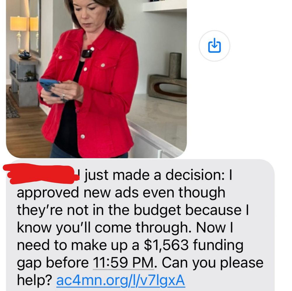 Fundraising text from Angie Craig, dressed in red, looking at a smartphone as if it's the first time she's ever used a smartphone, while wearing what appears to be a Rode Wireless Go II microphone.