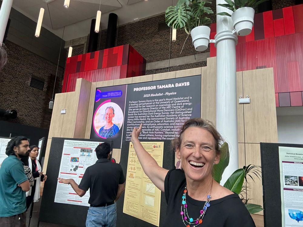 Tamara Davis pointing at a picture of herself on a big screen listing Moyal Medal recipients