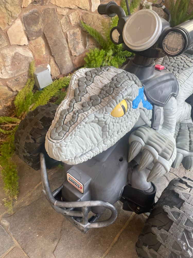 A Jurassic World-style velociraptor kids-size four-wheeler with a velociraptor body & head that would make it look kind the kid is riding the raptor