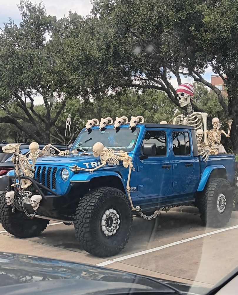 A blue truck covered in skeletons.
