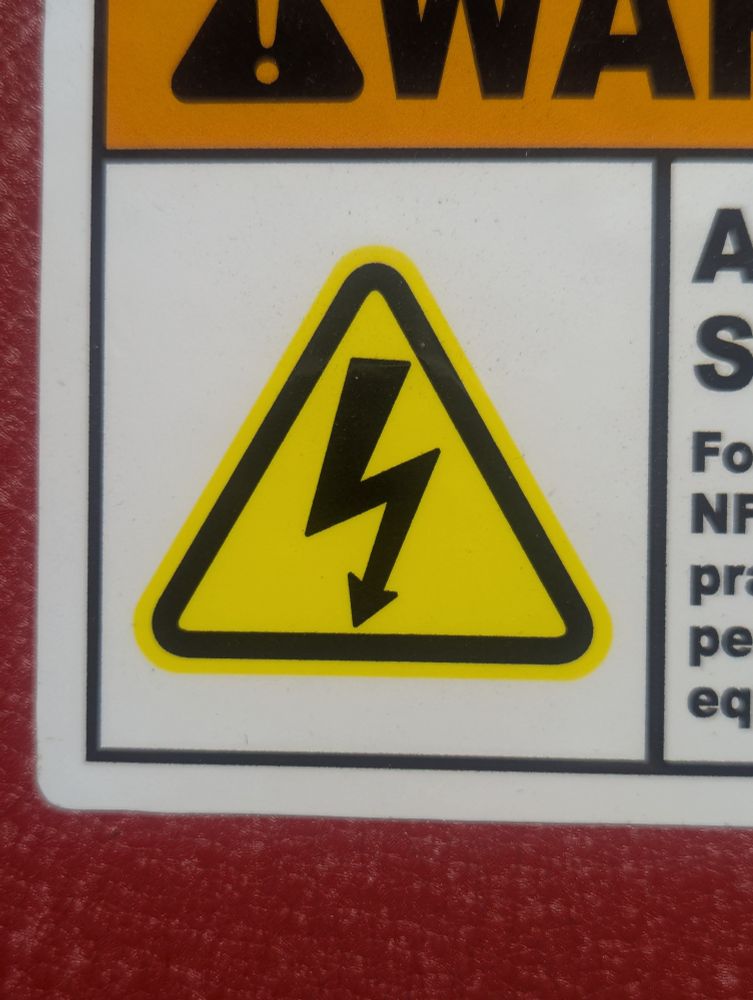 A standard NFPA electrocution warning logo, depicted by a lightning bolt within a yellow triangle.