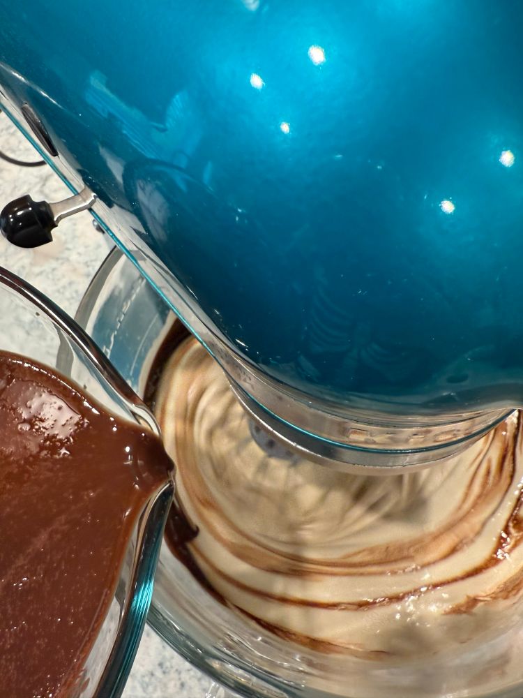 Brown butter/chocolate mix bring poured into the whipped eggs, forming a swirl in the batter. 