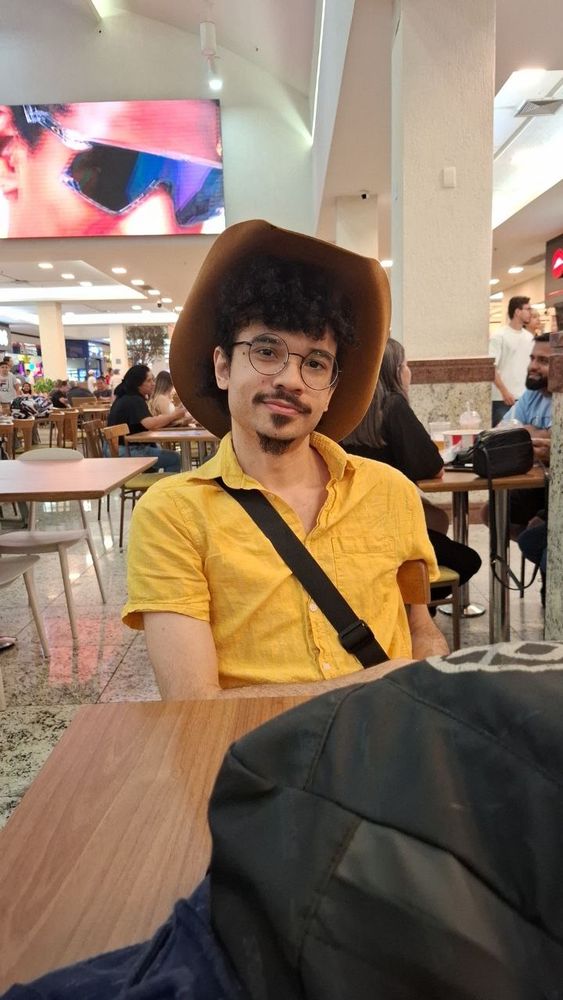 Foto do homem mais incrível do mundo, de camisa amarela e chapéu de cowboy.