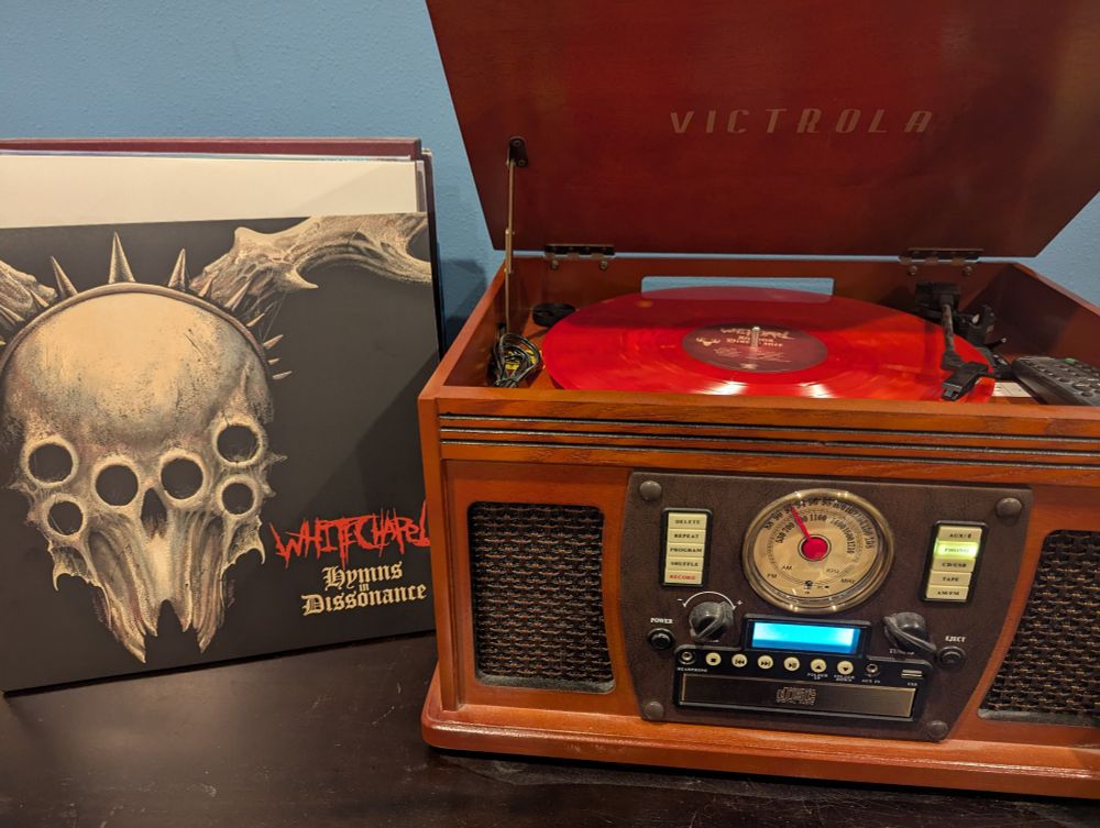 Record player spinning a vinyl copy of Whitechapel's album Hymns in Dissonance, with the album sleeve visible to the left
