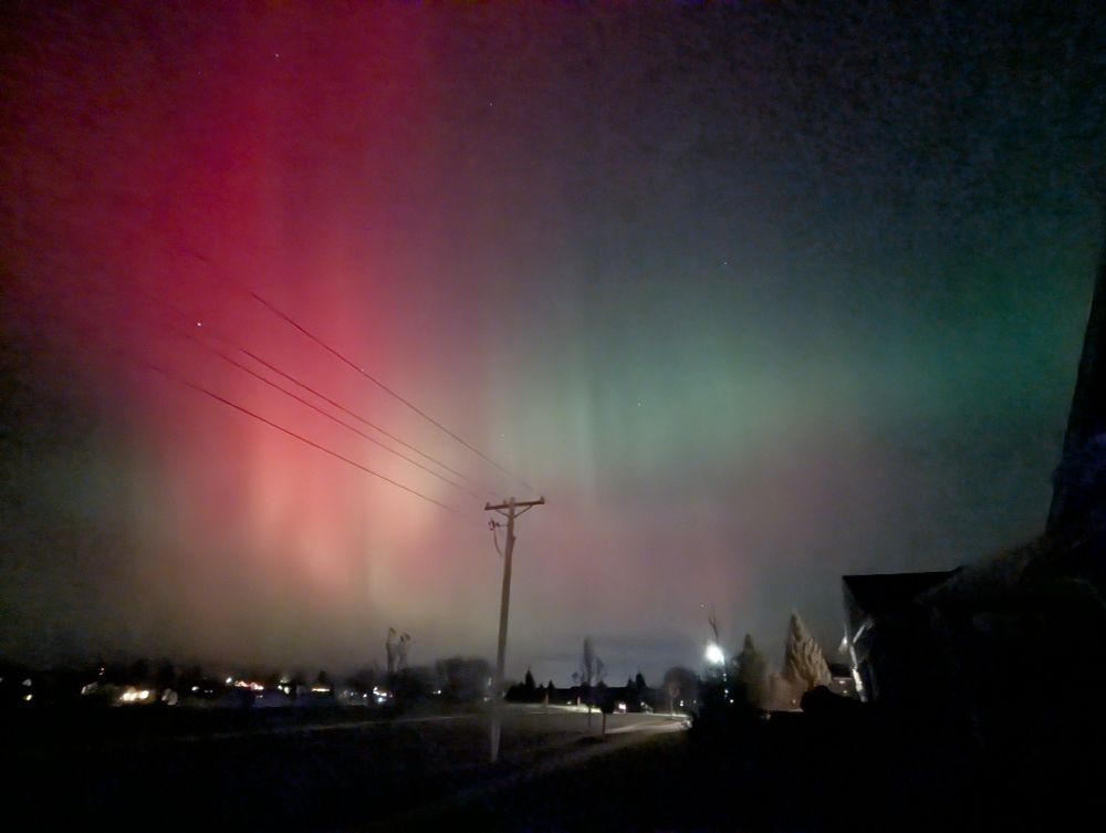 Pink and green aurora stretching across the sky
