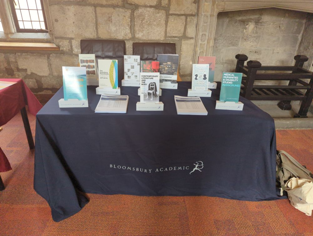 Photo shows a table with a Bloomsbury branded tablecloth, with ten Bloomsbury books on the table.