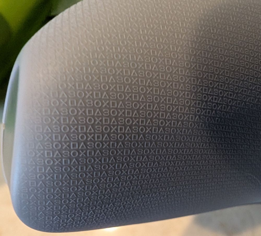 The handle of the 30th Anniversary Dualsense with the special 30th anniversary symbol micro texture