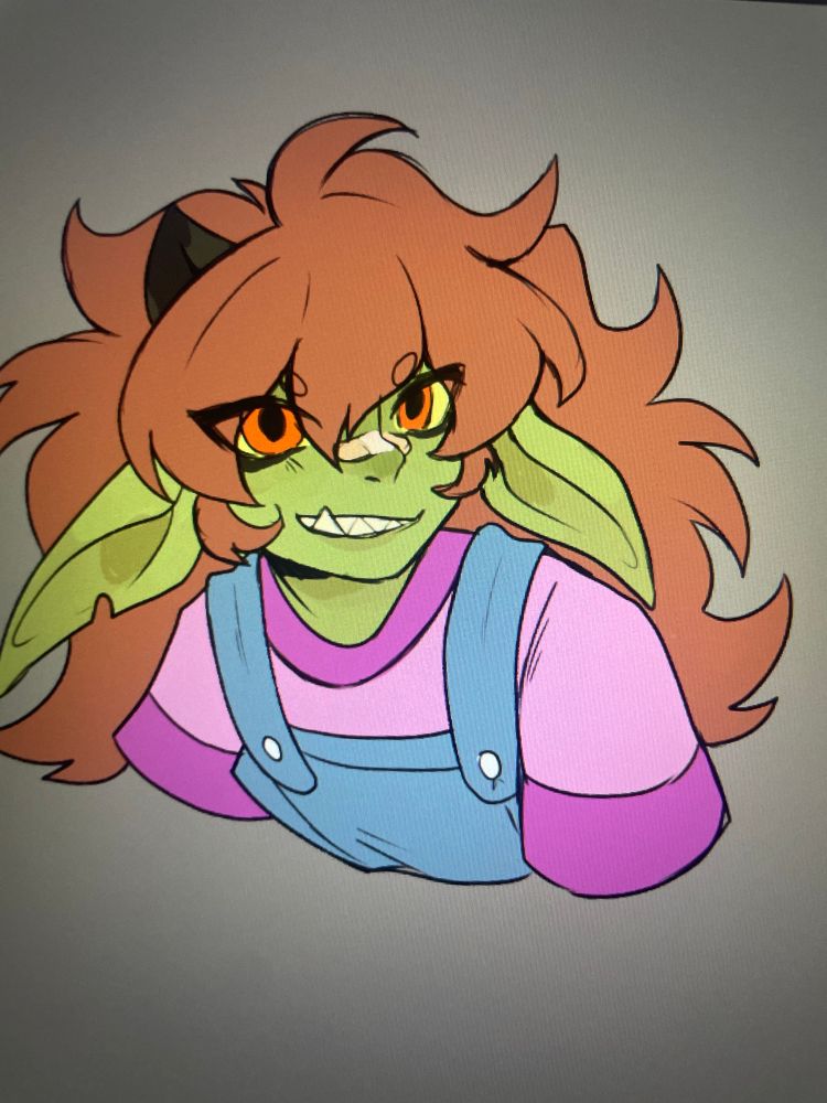 Yhu!! Little green goblin with orange eyes with messy long brown hair who dresses ln toddler sized shirts and overalls.