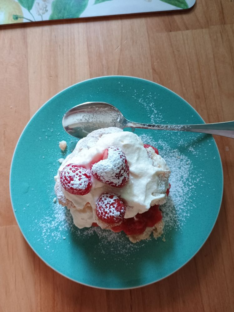 Blue green plate with a spoon ready to dig in. Shortcake made from scratch with fresh strawberries and topped with real whipped cream and dusted with powdered sugar. This was my late mom's specialty and making it brought back so many memories.