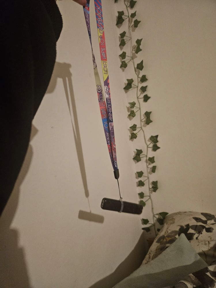 A black vape hanging on a colourful lanyard