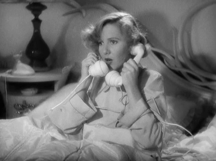 Black and white movie still of a white, light-haired woman sitting in her bed with a rotary phone handle in each hand against each ear. There's a shocked expression on her face. 

(Source: Jean Arthur in Easy Living (1937))