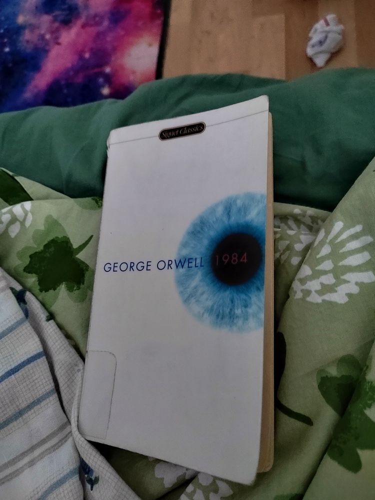 A front cover of George Orwell's 1984, mostly white cover with a blue eye. 
