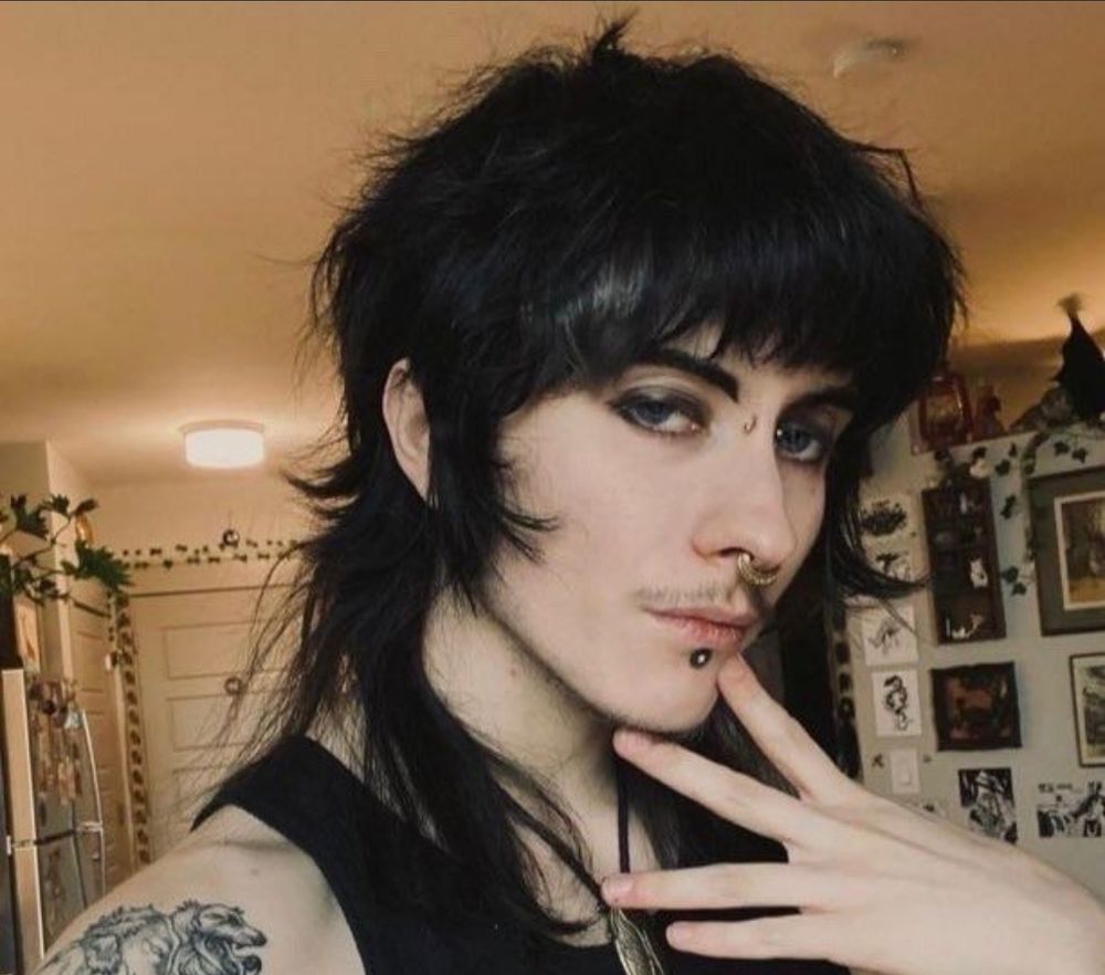 photo of a androgynous person posing, they have black hair with large and prounounced bangs with long hair in the back