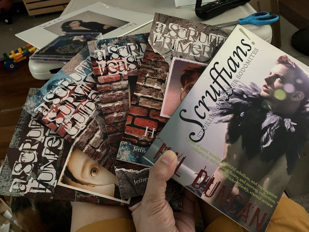 5 Scruffians books held like a fan! on the table in the bg are Laufey’s TYPICAL OF ME in vinyl & Sinead O’Connor’s SHE WHO DWELLS… on CD