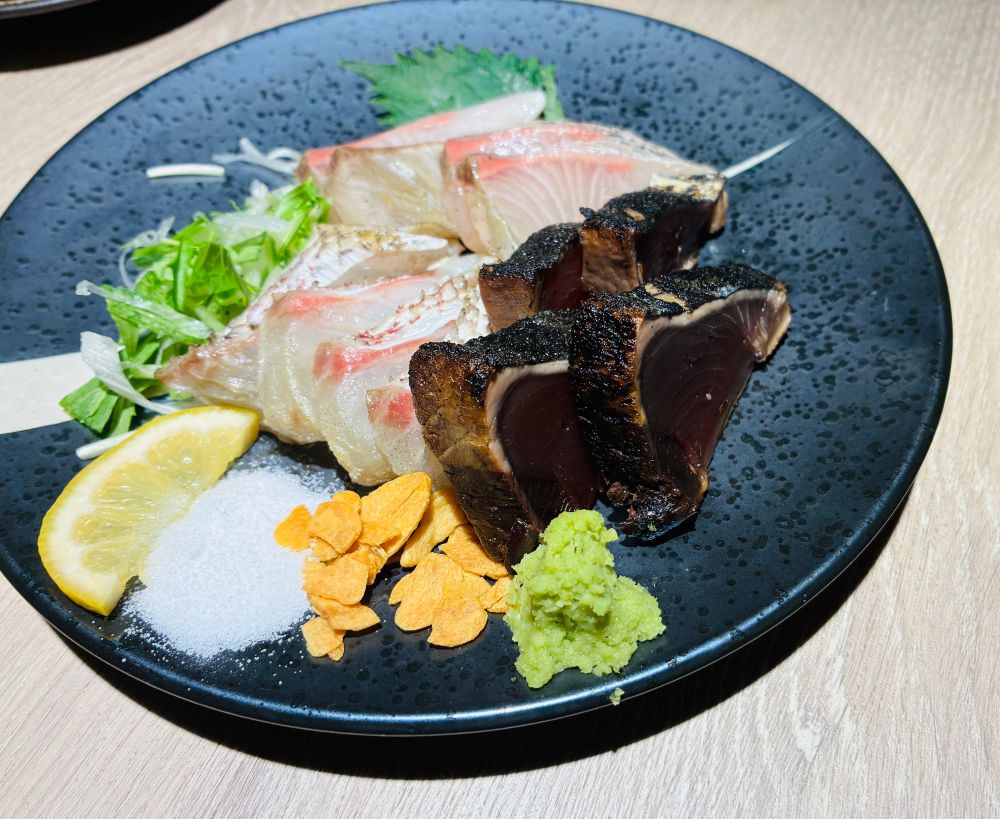 青いお皿に乗っている刺身の盛り合わせ