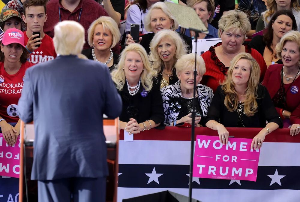 Several blonde women gazing lovingly at Trump during a political rally. 