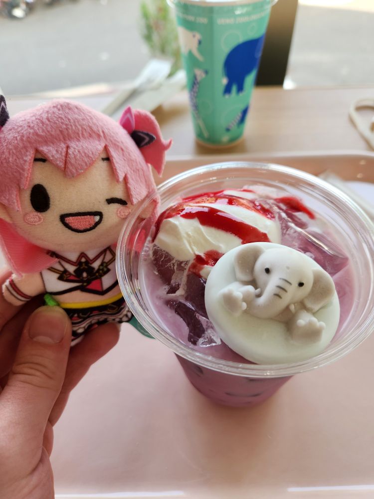 Airi held next to a purple float drink with a big elephant marshmallow in it