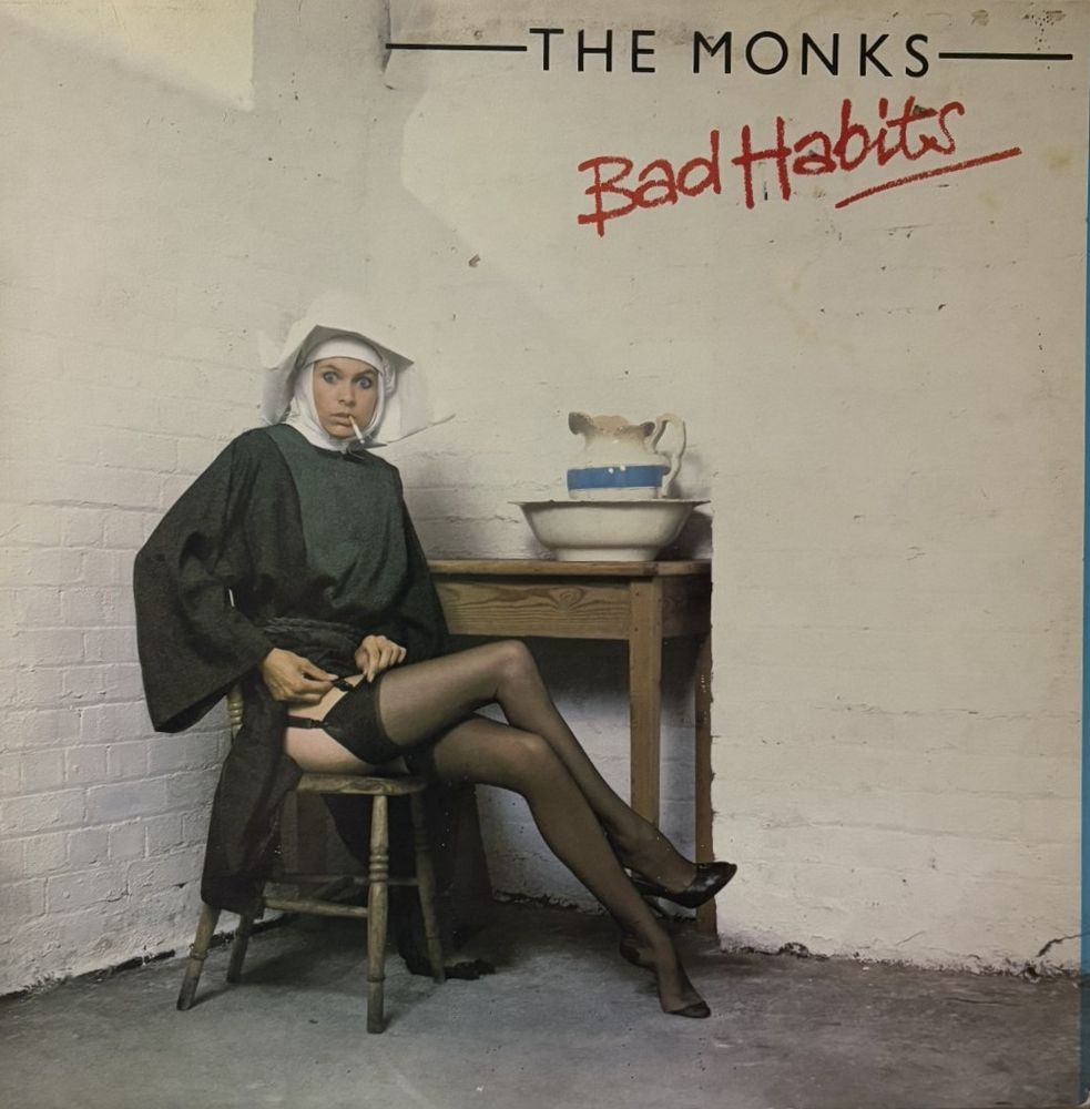 An album cover depicting a nun in a sparse room wearing heels, stockings, and a garter belt, adjusting her garter and smoking.  The group is called The Monks and the album is called Bad Habits.