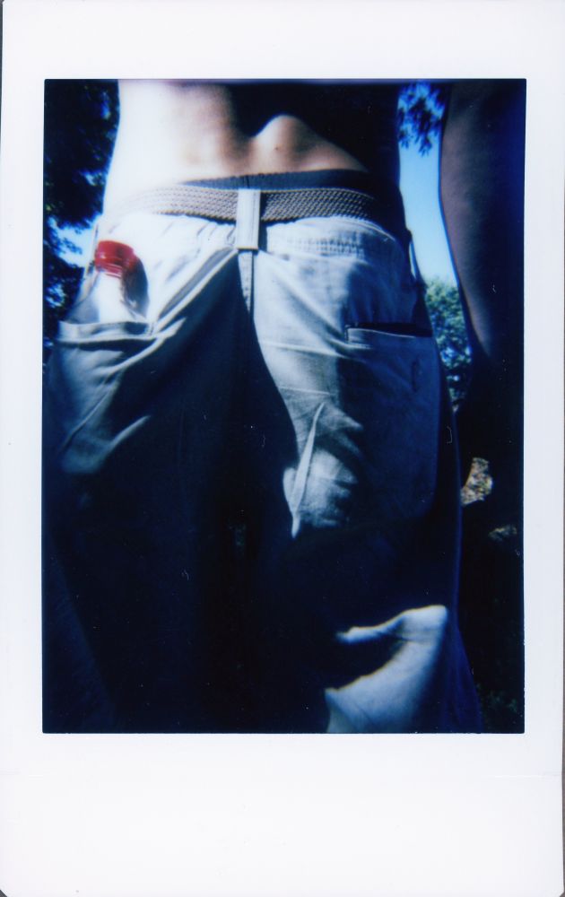 Photo from behind of man in shorts with bottle in his back pocket.