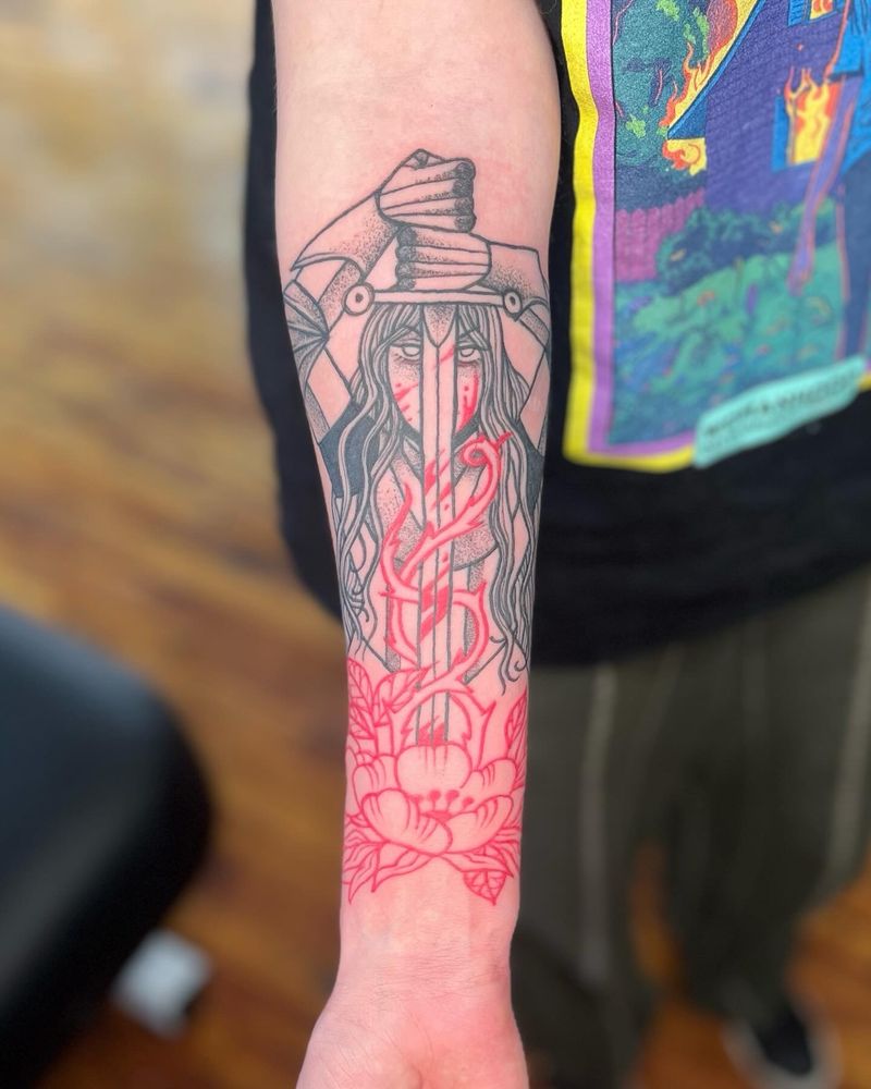 a tattoo of a lady knight with messy long hair holding a sword point down in front of her face done in black ink. the sword is slicing through vines and roses done in red