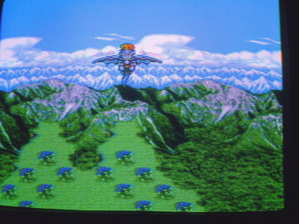 A photo of Final Fantasy 5 showing a dragon taking flight across a mountain range 