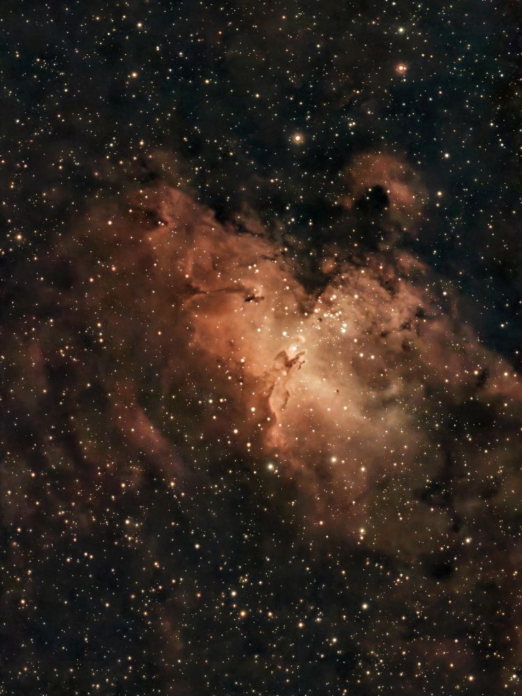 Backyard telescope view of the Eagle Nebula, with the Pillars of Creation standing out as a small feature in its center.