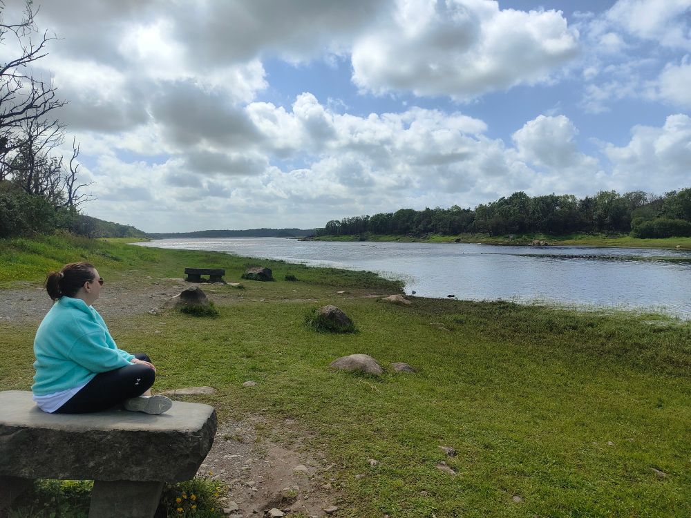 Linda sitting on  a rock overlooking the river in Coole Park,  County Clare. 