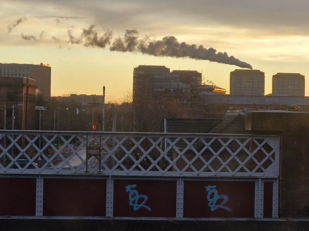 Glasgow skyscape, smoke/steam from a chimney blowing across beautiful glowing sunrise