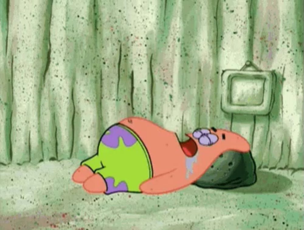 patrick star from spongebob squarepants is laying on the ground with his eyes closed .