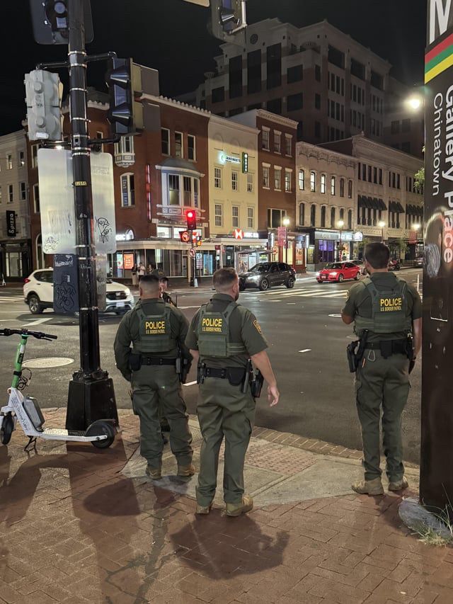 Three uniformed Border Patrol agents standing at the corner of 7th & H St. N.W., near an entrance of the Gallery Place/Chinatown Metro station. 