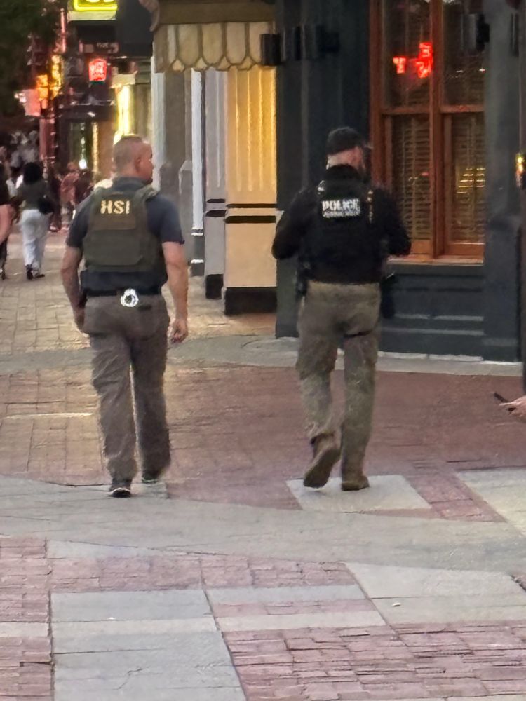 Two uniformed Homeland Security Investigations agents patrolling a sidewalk in the Chinatown neighborhood of D.C. 