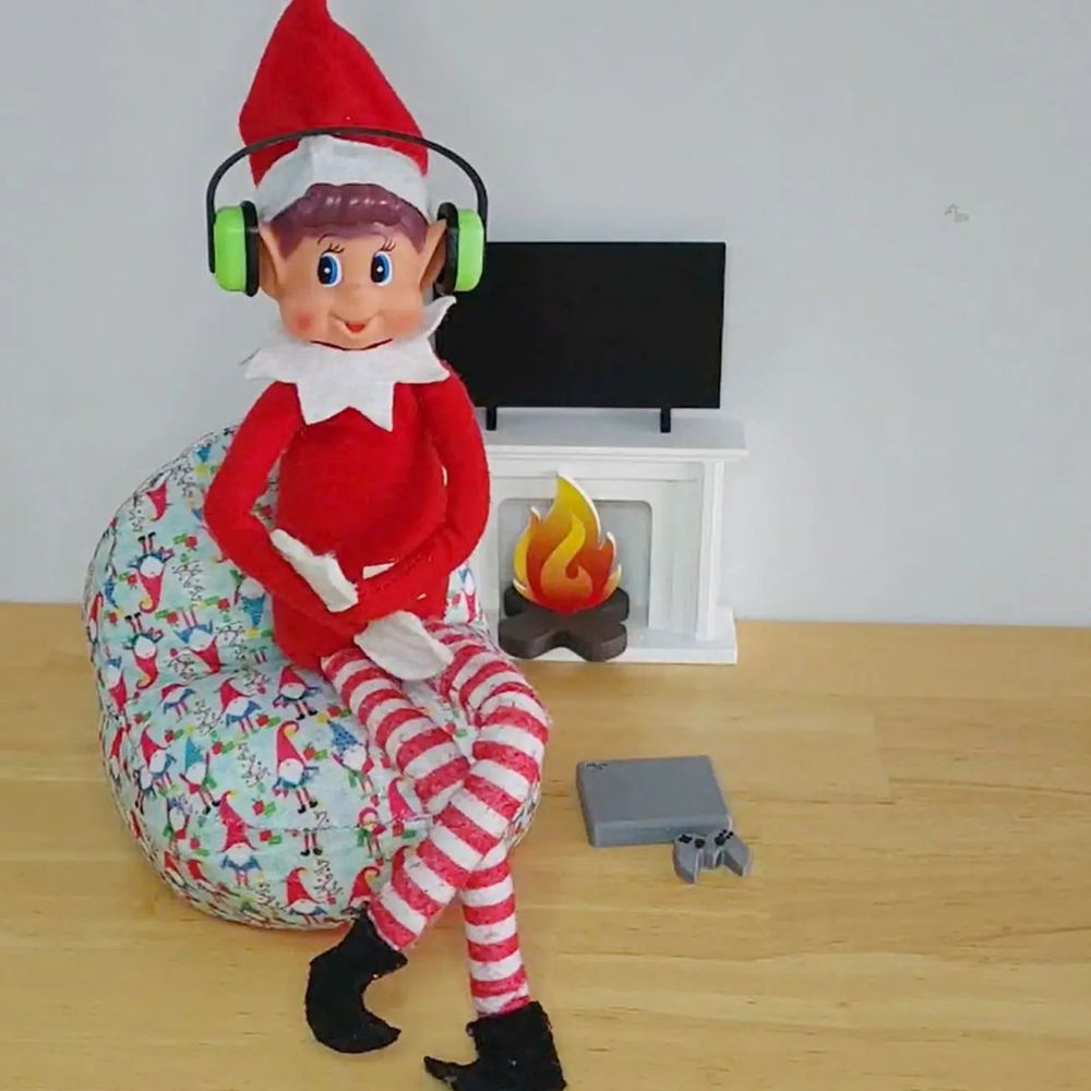 A Christmas elf wearing lime green headphones sitting on a beanbag chair