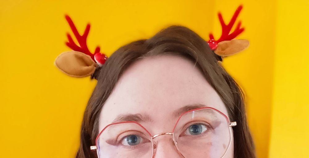 Photo portrait coupé à la base du nez, avec des pinces oreilles de cerf dans les cheveux.