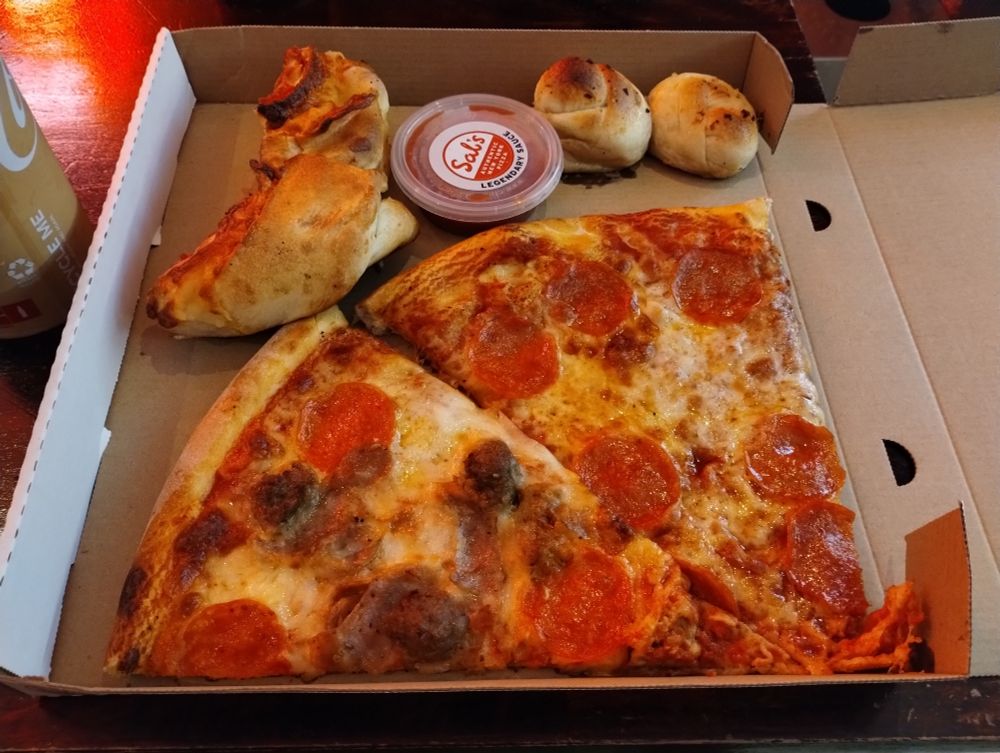 Pizza and garlic scrolls and sauce tub in a pizza box