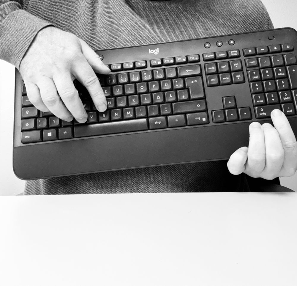 Der User hält seine Tastatur vor seinem Körper, um es aussehen zu lassen, dass es eine Gitarre wäre.