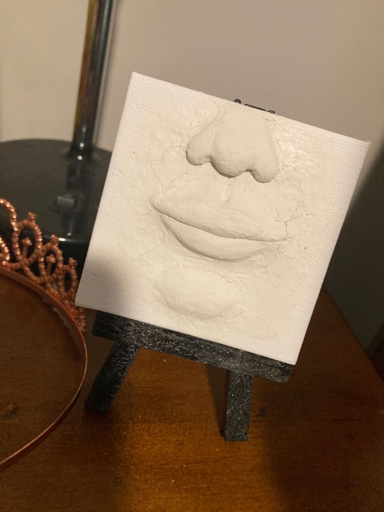 Face imprint on mini canvas with molding clay 