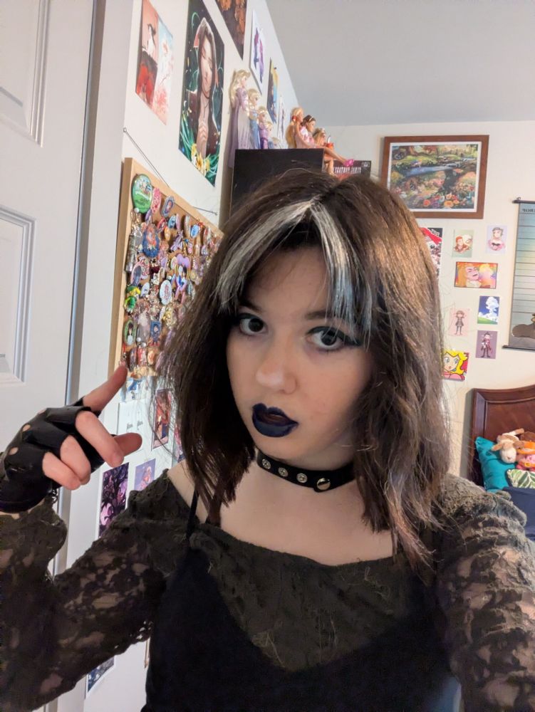 A selfie of my closet cosplay. I have dark blue eyeshadow and lipstick on, and am pointing 