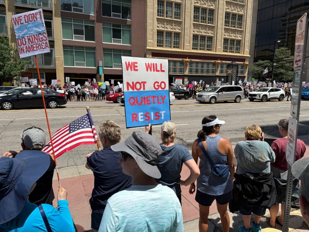 People with No Kings Day protest signs