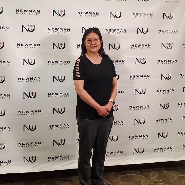 Female in a black shirt in front of Newman backsplash