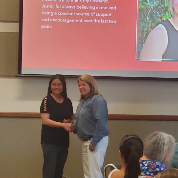 Woman with black shirt receiving pinning ceremony from Dean, Dept. Of Social Work  at Newman University 
