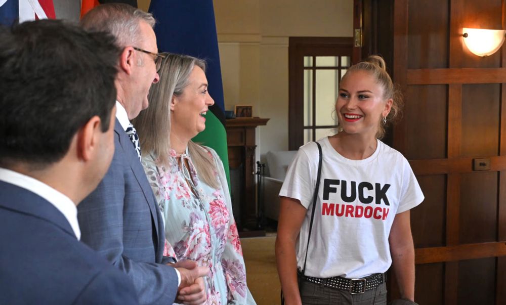 Grace Tame in a 'Fuck Murdoch" t-shirt pictured with the Prime Minister of Australia at some Australian of the Year morning tea